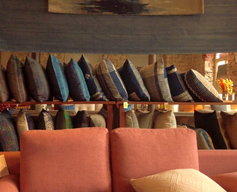 Couch with a shelf of throw pillows behind it in a furniture store